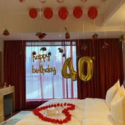 Romantic hotel room with red and white balloons and floral arrangement