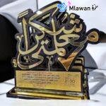 Personalized teacher plaque engraved with "شكرا معلمتي" on wooden desk